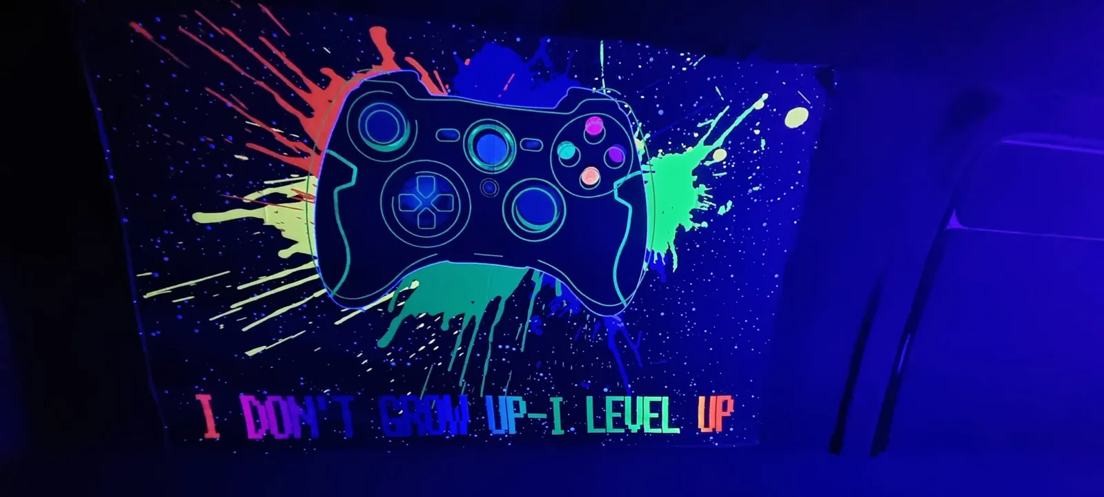 Colourful controller artwork glowing under the van's UV lighting